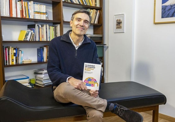 Baltasar Rodero, con su libro, sentado sobre el sillón en el Centro Rodero, en Santander.