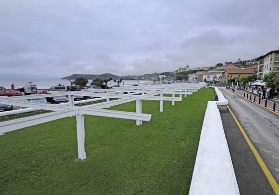 Vial de dirección única por el que se accede a la playa de Comillas, con un paso destinado a los peatones a la derecha.