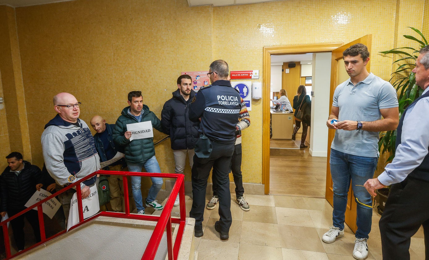 El edil de Deportes, Nacho González (derecha), a punto de entrar en el salón de plenos, con varios de los agentes concentrados al lado, en la escalera. 