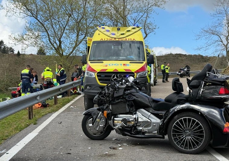 La moto accidentada en el lugar del accidente con los servicios de emergencias atendiendo a los heridos.