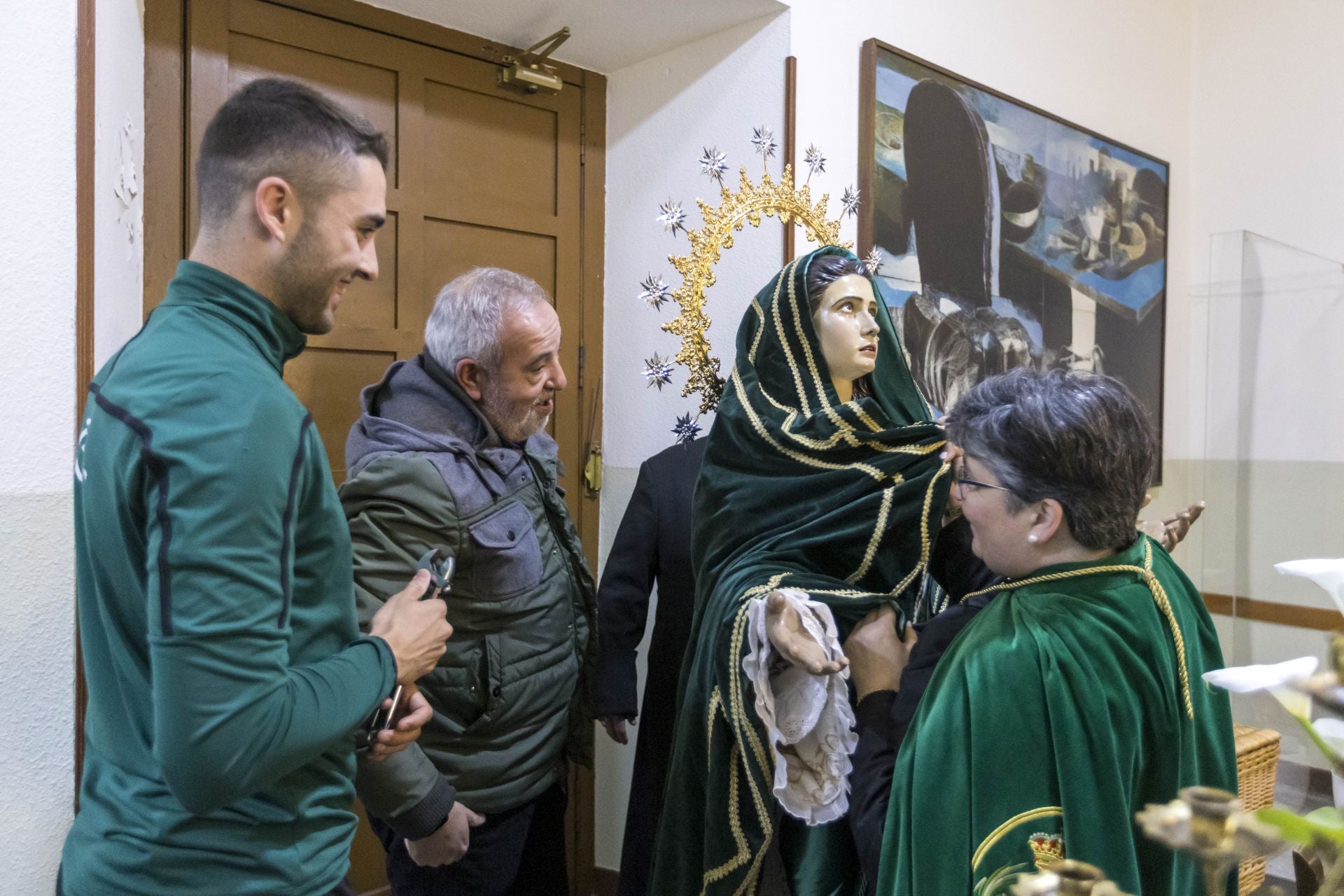 Los cofrades preparan a la virgen para trasladarla a la parroquia.