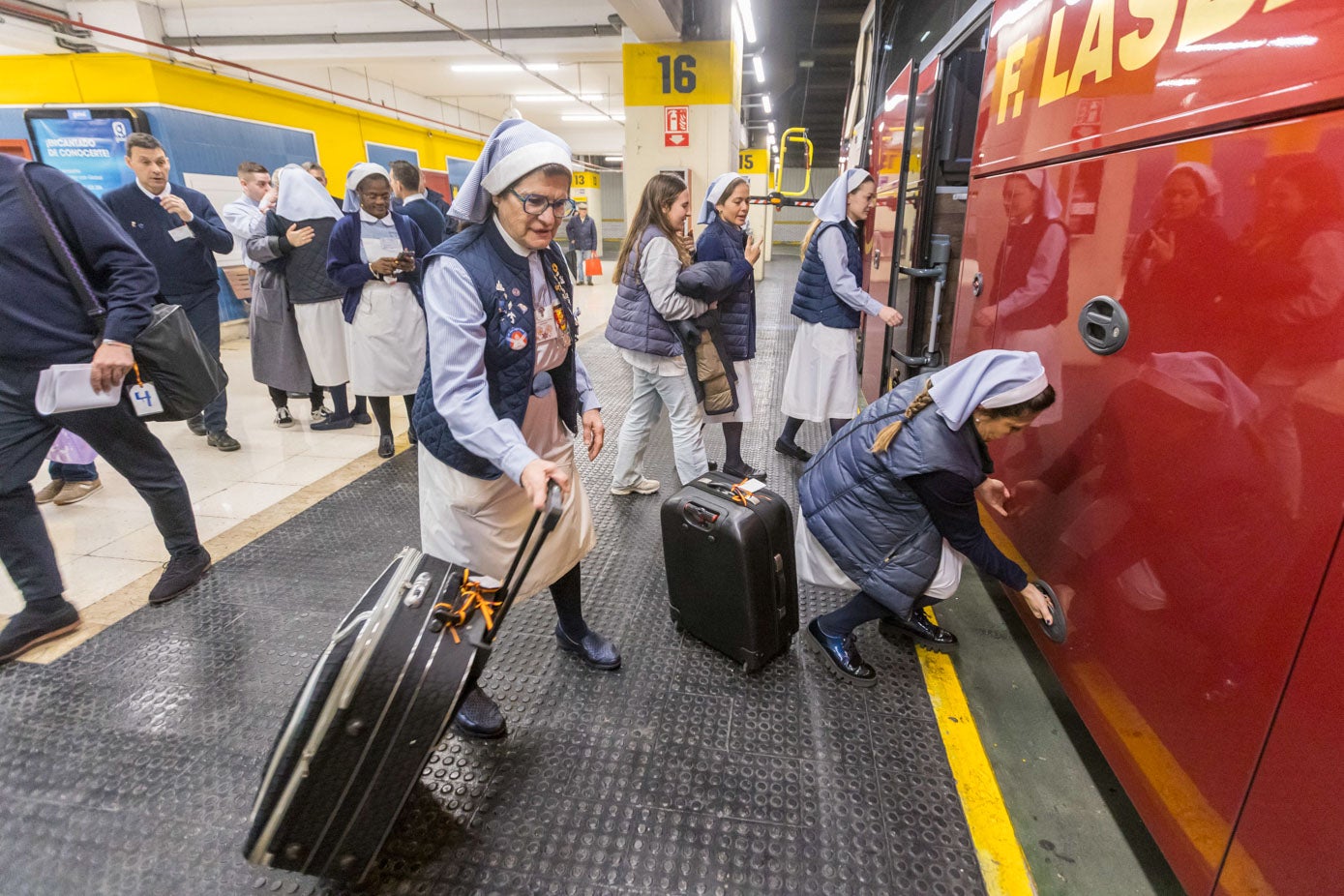 Un grupo de 'Damas' meten sus maletas en uno de los diez autobuses que han salido este lunes desde la estación de autobuses de Santander. 
