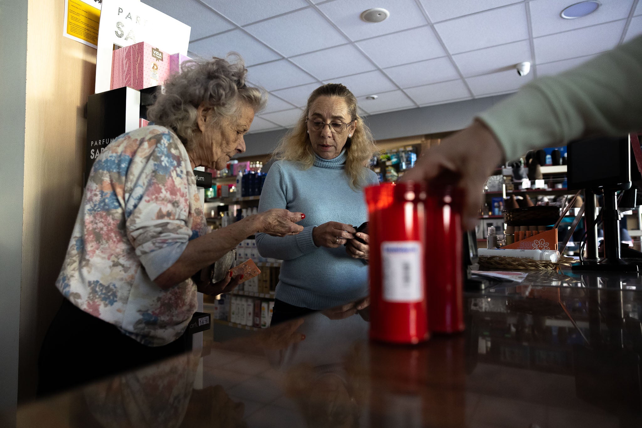 Un par de clientas compran velas en un establecimiento.