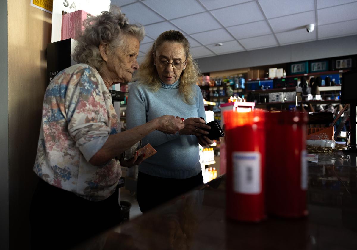 Una mujer compra velas en la calle Castilla de Santander.