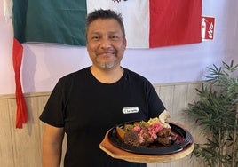 Mario, delante de la bandera de Mexico, lleva 22 años en España.