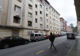 Un vecino cruza la calle frente al número 9 de la calle Marqueses de Valdecilla y Pelayo, en Torrelavega.