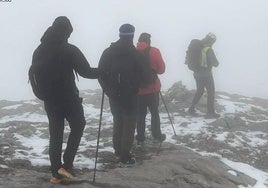 Los jóvenes guiados entre la niebla por uno de los rescatadores del Greim de la Guardia Civil.