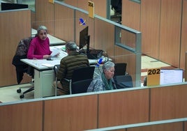 Funcionarios atienden a ciudadanos en una oficina de Hacienda.