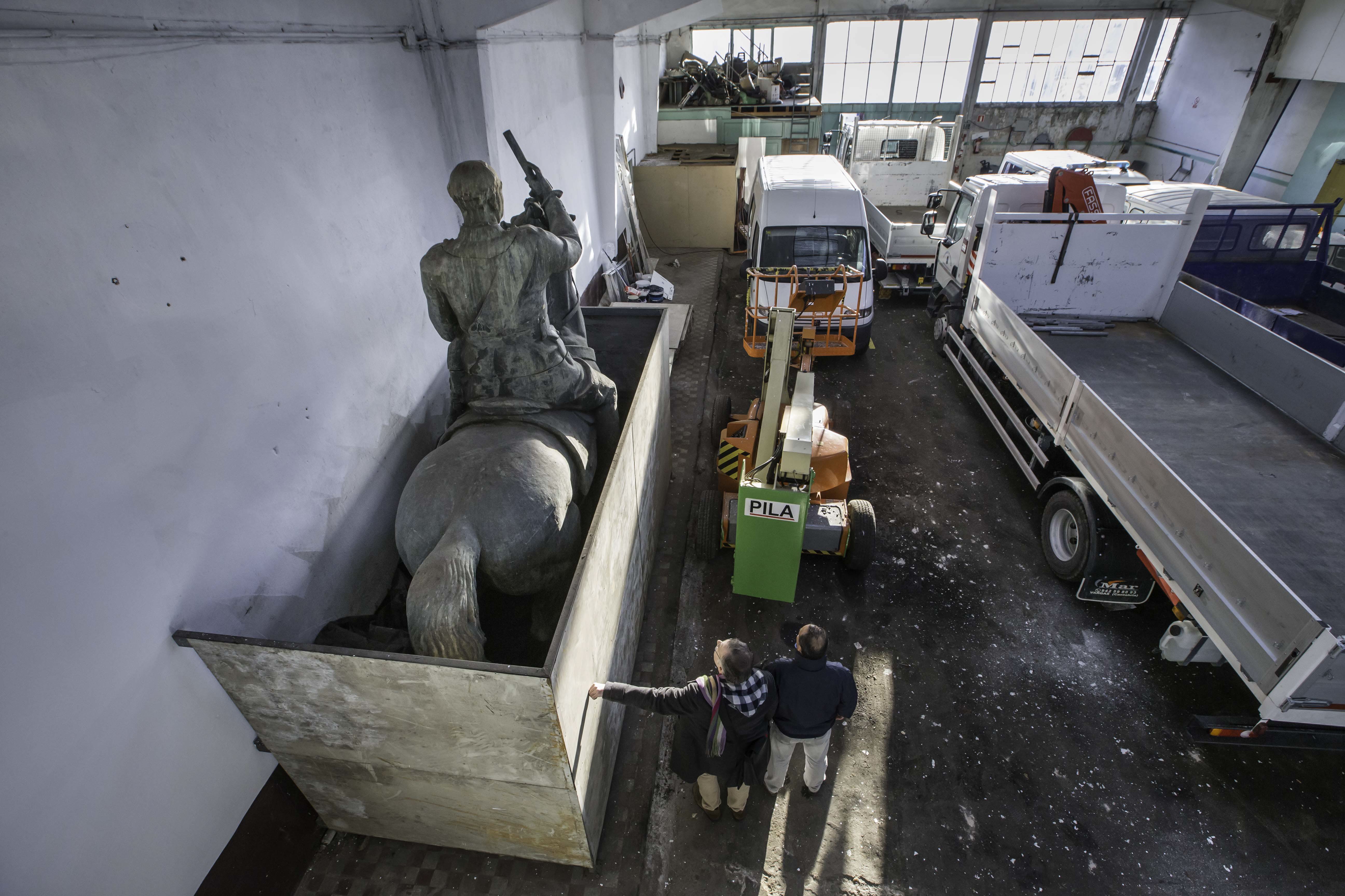 La estatua de Francisco Franco, protegida por una estructura metálica y chapas de acero, fue depositada en el almacén municipal de Cajo junto a vehículos del Ayuntamiento de Santander.