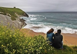 Una pareja disfrutando del paisaje en una playa de la región.