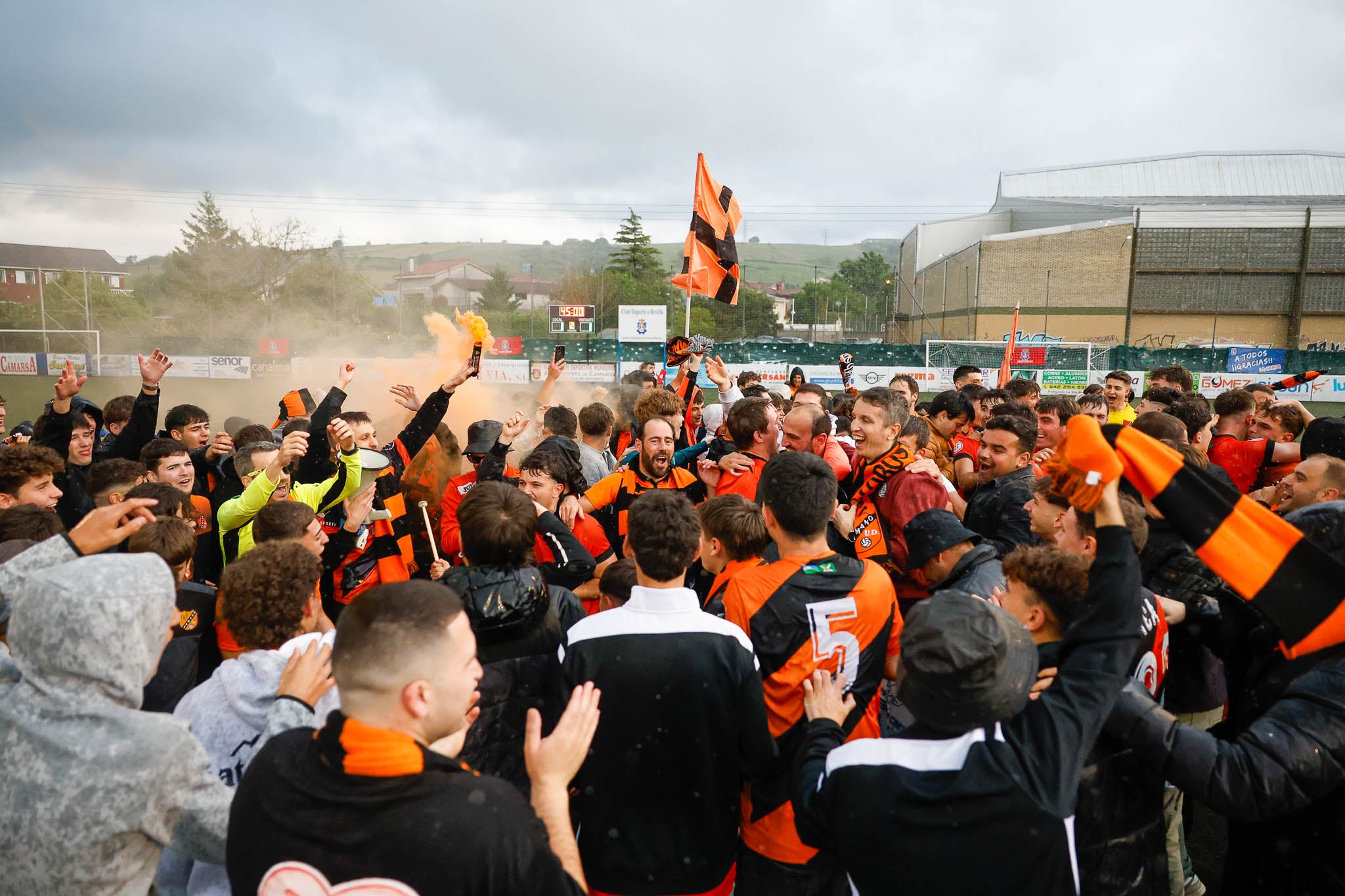 Futbolistas y aficionados con bengalas al acabar el partido.