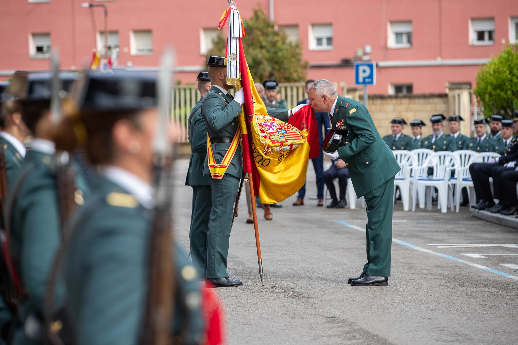 Un guardia retirado besa la bandera.
