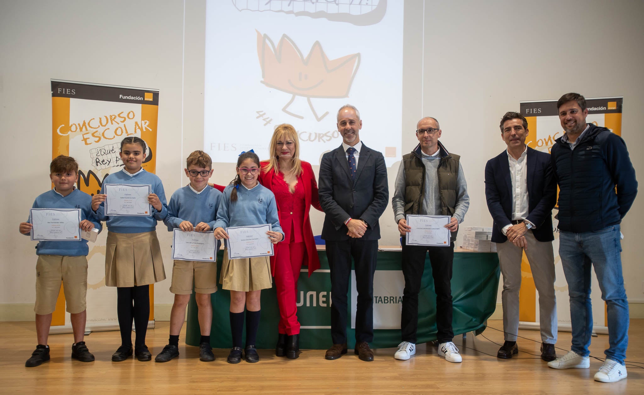 Los cuatro escolares del Colegio Sagrados Corazones de Torrelavega, junto con las autoridades y sus profesores, en el estrado del salón de actos de la UNED. 