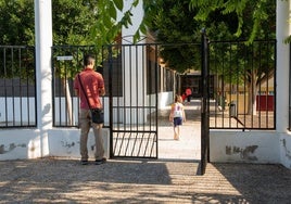 Un padre despide a su hija a la puerta del colegio.