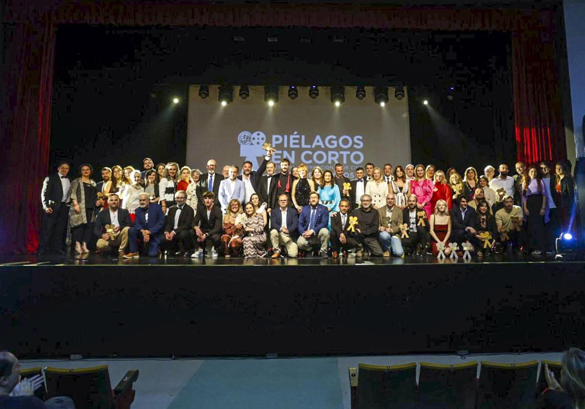 Foto de familia de los galardonados, organizadores, representantes institucionales y presentadores de la gala de clausura del XV Festival de Cine de Piélagos