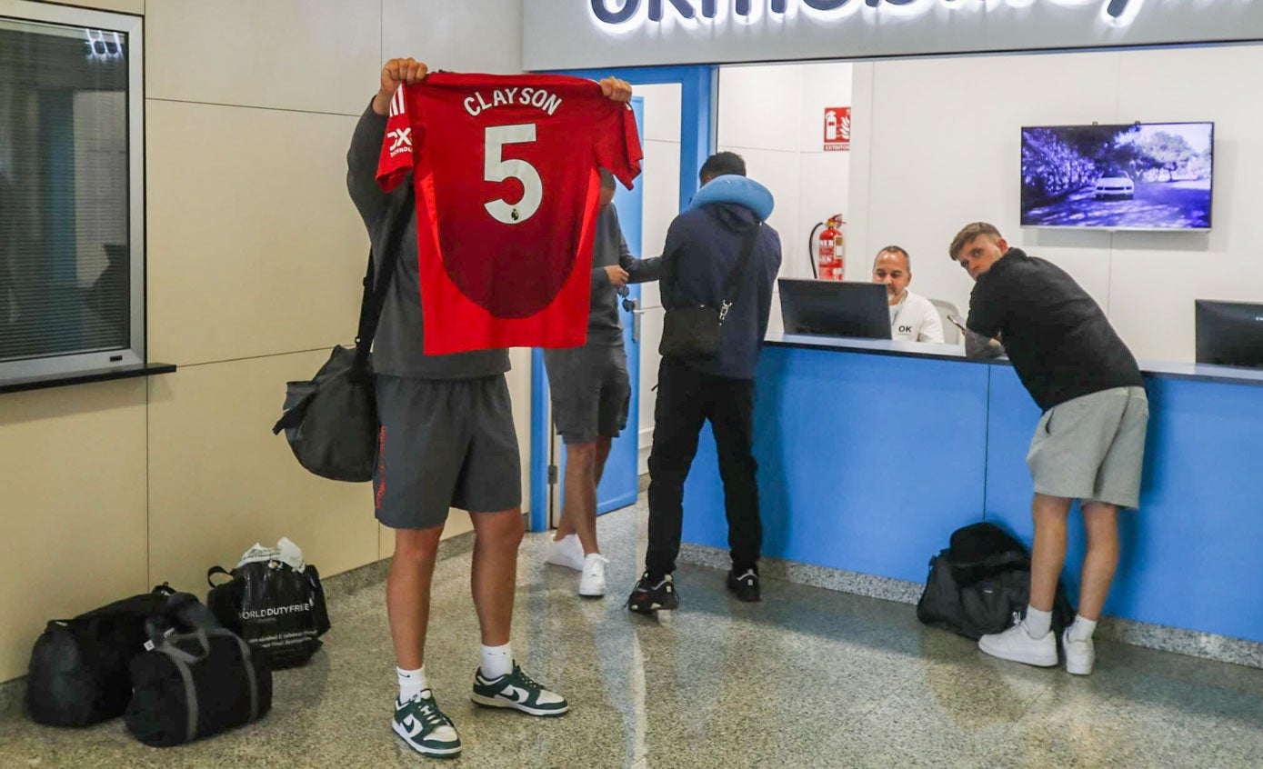 Un aficionado del Manchester United enseña la camiseta de su equipo, aún en el aeropuerto de Santander.