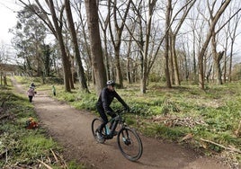 Un vecino circula con su bicicleta por una de las sendas del parque de Las Tablas, en Torrelavega.