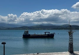 La draga trabajando en la bahía de Santoña, a la altura e la plaza de toros.