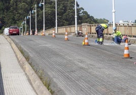 Obreros trabajan en la calzada del puente de Somo.