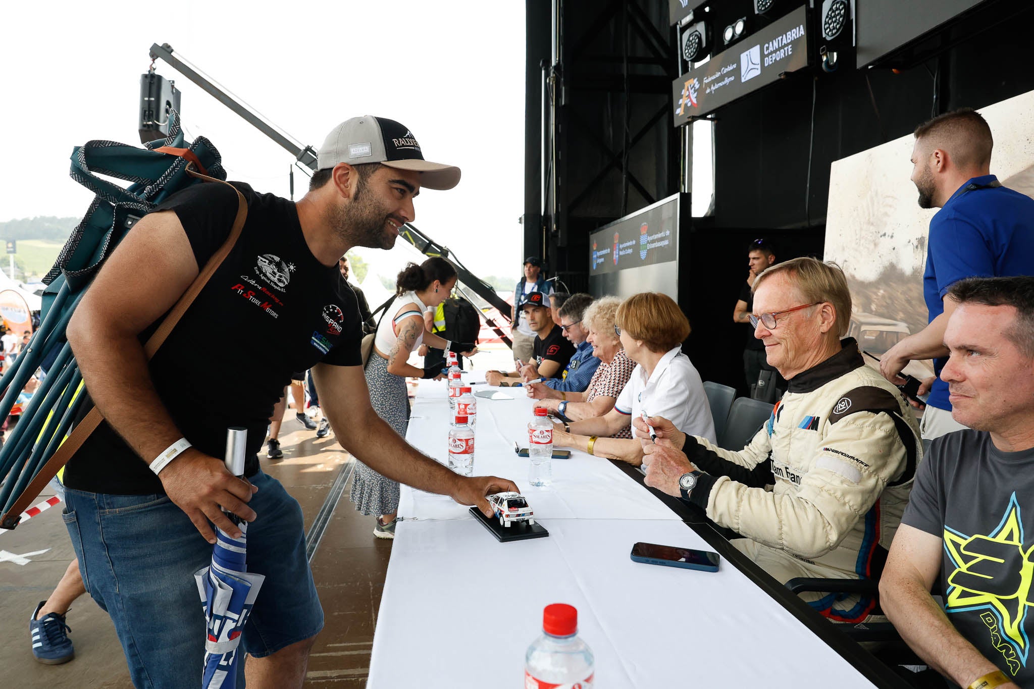 Ari Vatanen se dispone a firmar en un coche en miniatura.