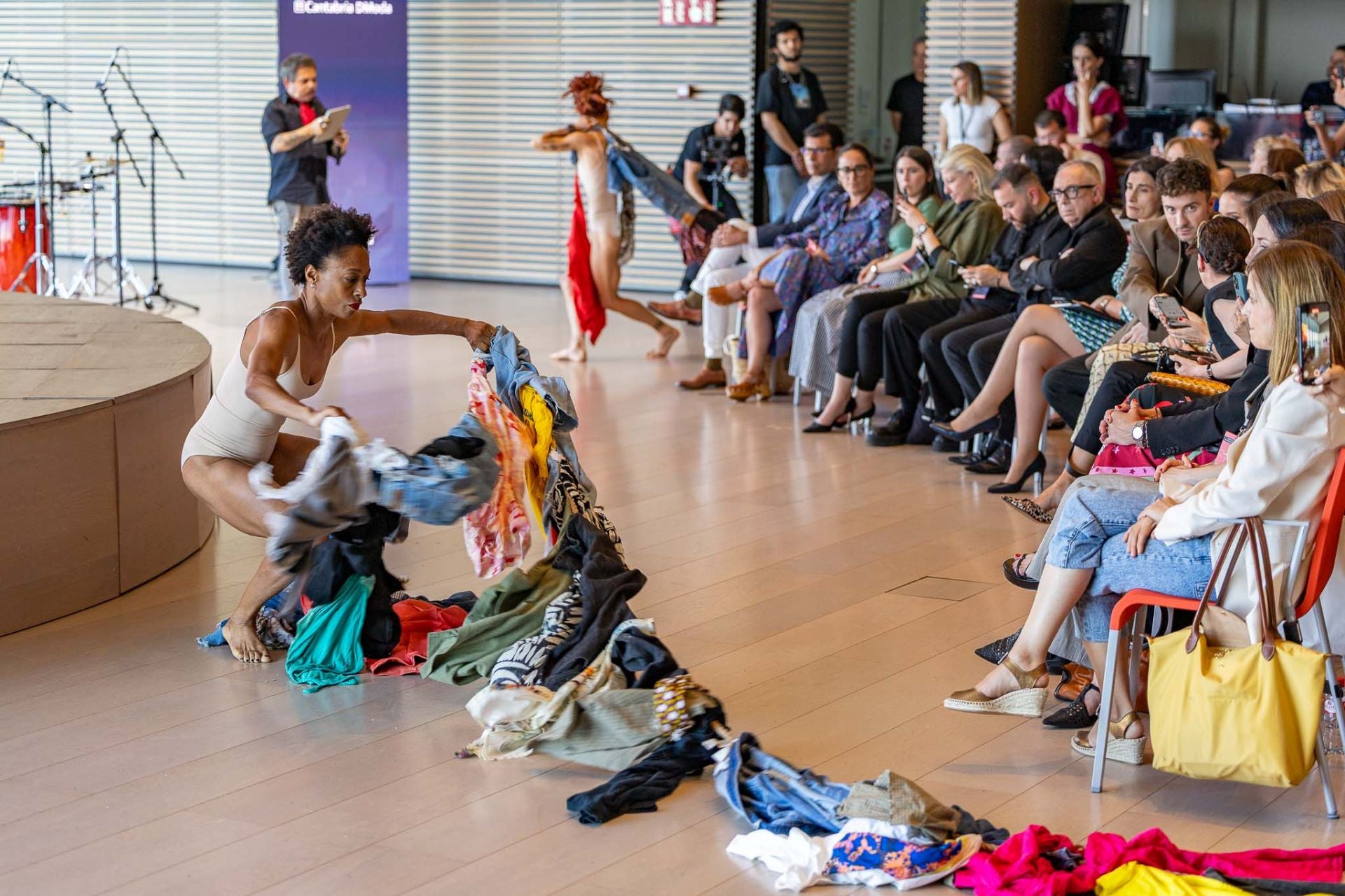 La Asociación de Creadores de Cantabria cerró Espacio DModa con el espectáculo 'SOS', una impactante multidisciplinar ideada por María José Pereda de Castro y José Luis Callejo. Con danza, palabra y diseño, la pieza denunció la brutalidad de la industria textil y reivindicó un futuro más justo y sostenible. Destacó el vestido escultura de la artista Tytti Thusberg, realizado en sisal reciclado con técnicas artesanales y cristales de lámpara. La puesta en escena, con coreografías de Monty Lima y Mónica Yunquera, y la voz de Jimmy Barnatán, representó la lucha de los cuerpos atrapados entre los hilos de un sistema insostenible.