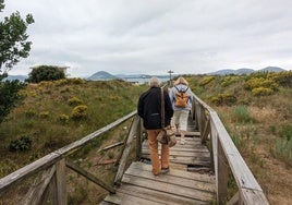 Dos turistas pasan por la pasarela en el verano de 2023, antes de ser arreglada por el Ayuntamiento pejino por primera vez.