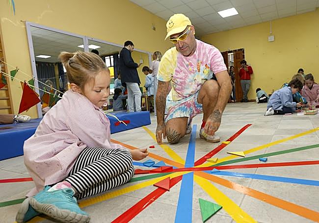 El artista juega con una de las participantes del proyecto, en el colegio Menéndez Pelayo.