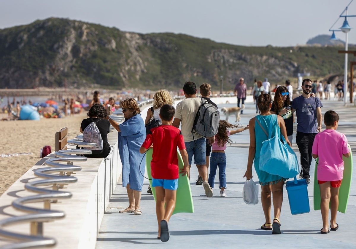 Varios grupos de personas pasean por el paseo marítimo de Suances el pasado verano.