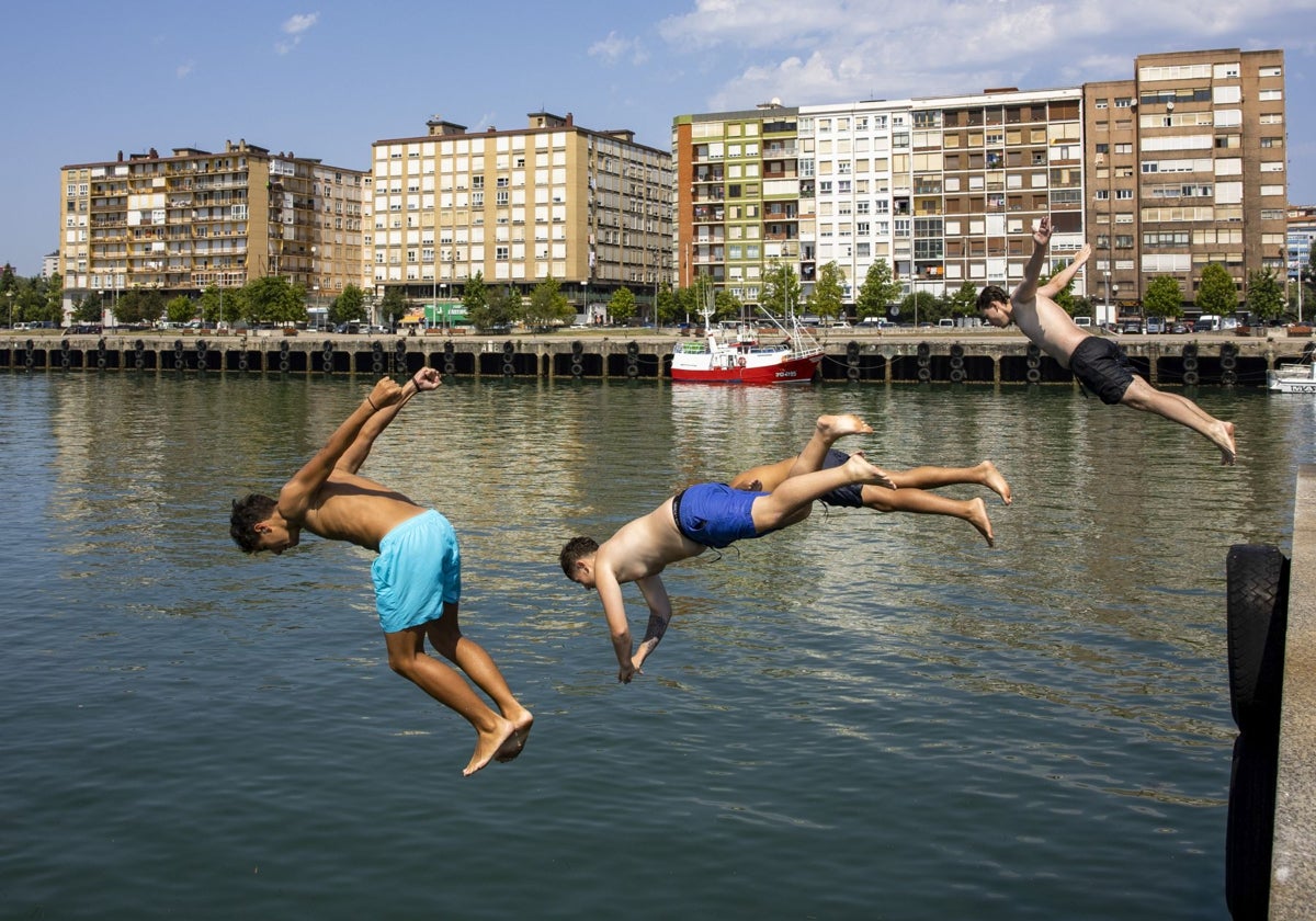 Unos jóvenes se tiran al agua en el Barrio Pesquero de Santander durante la ola de calor sufrida el mes de agosto del pasado año.