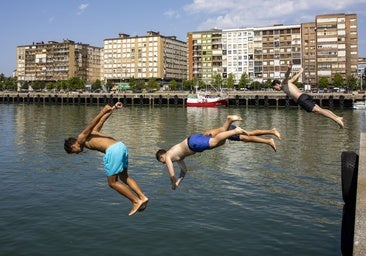 Unos jóvenes se tiran al agua en el Barrio Pesquero de Santander durante la ola de calor sufrida el mes de agosto del pasado año.