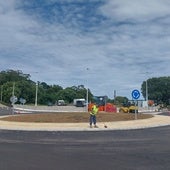 Un operario da los últimos retoques a la glorieta mientras se asfalta el vial.