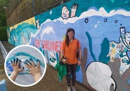 La artista Paula Vallar posa junto al mural en el colegio de El Sardinero.