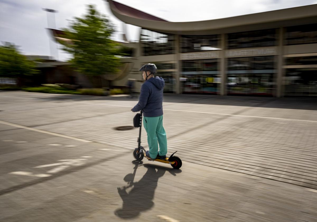 Un hombre circula con su patinete frente a la Estación Marítima.