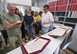 El técnico Álvaro del Castillo (derecha) muestra el libro que contiene la concesión a Santander del Título de Ciudad en 1755.