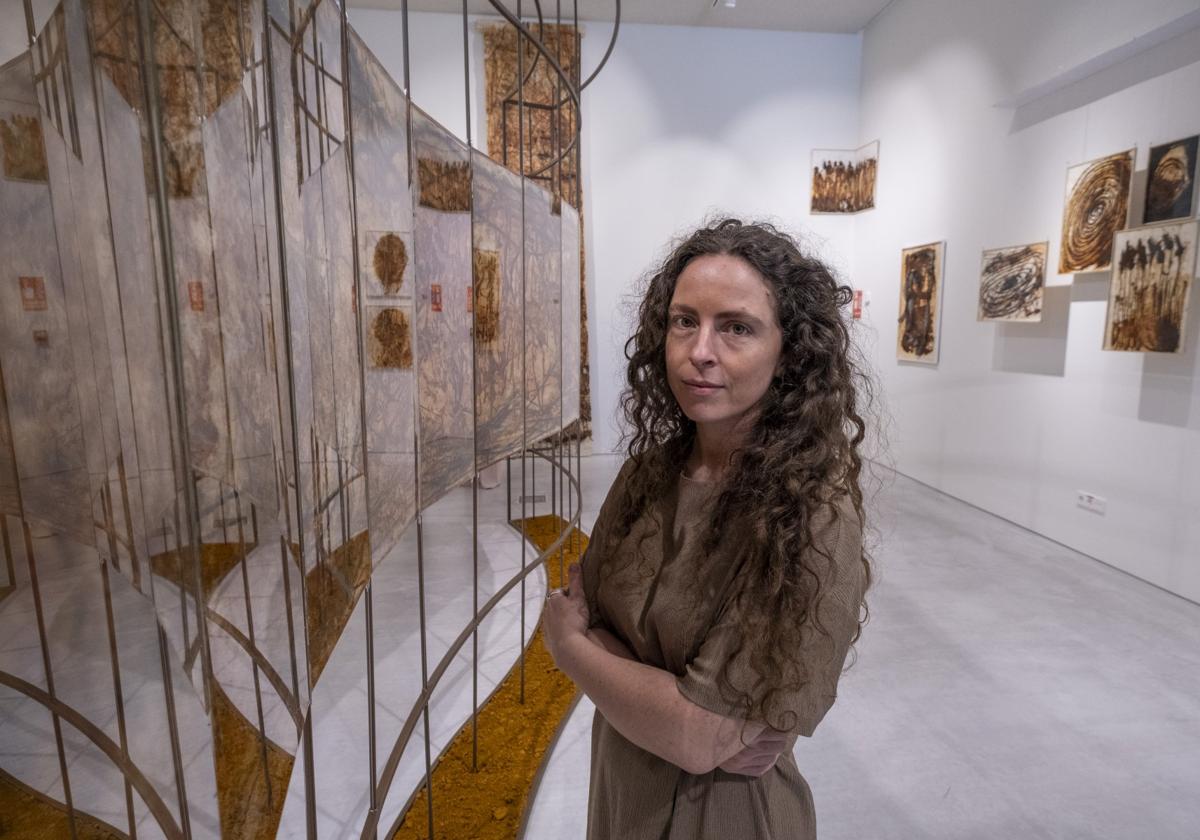 La artista santanderina María Villacorta posa junto a la obra 'Río Rito', que marca el recorrido a seguir en la exposición.