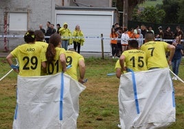Participantes de una de las peñas festeras en la carrera colectiva de sacos
