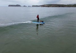 Marcos, sobre la tabla con su perra Hera, que se proclamaron ganadores de la competición celebrada en La Concha (Suances).