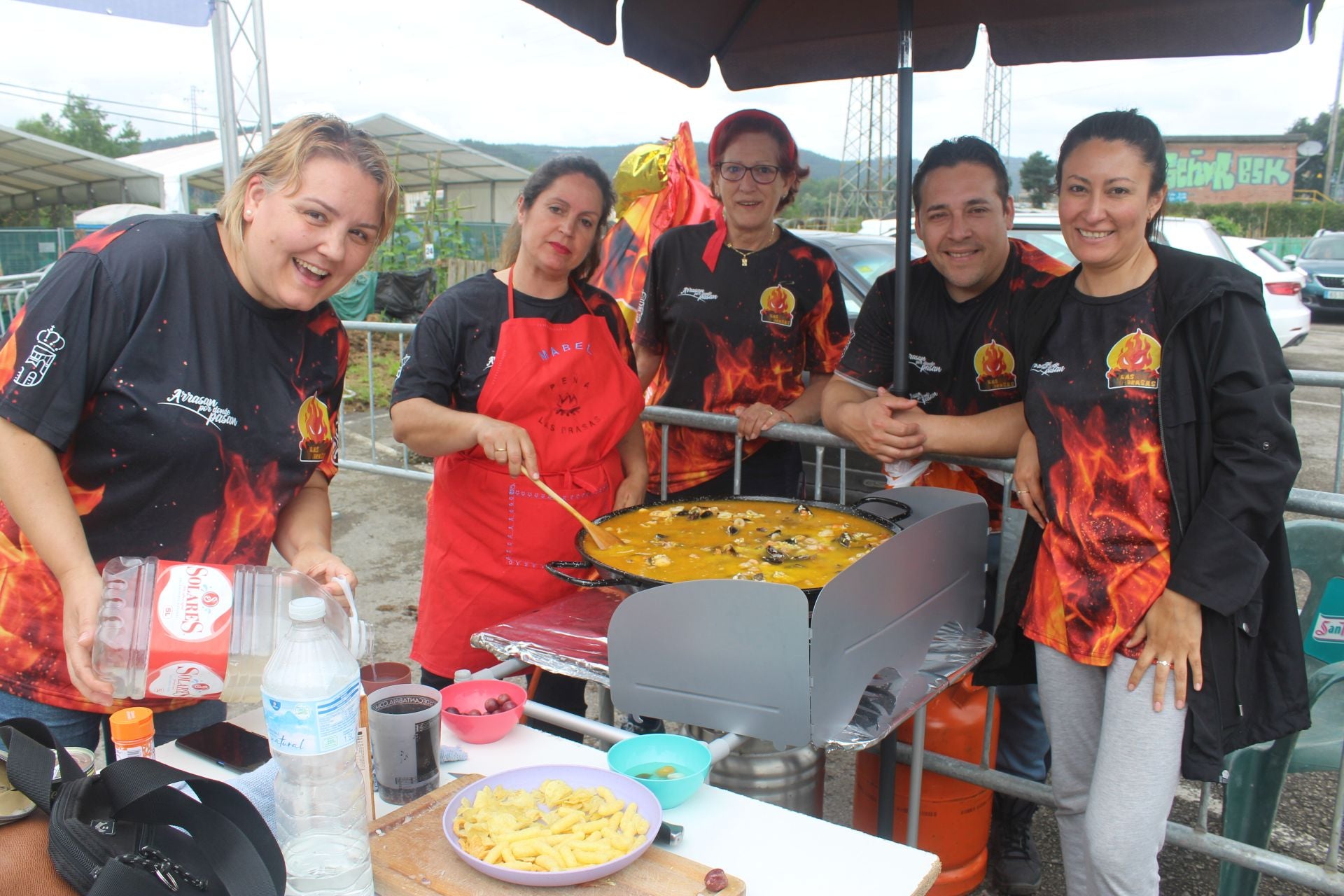 Las chicas de Las Brasas midiendo el caldo que echan a la paella.