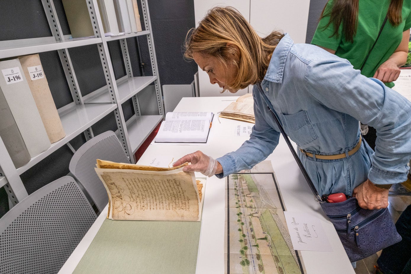 Una visitante hojea un documento antiguo, una Real Ejecutoria de 1511.