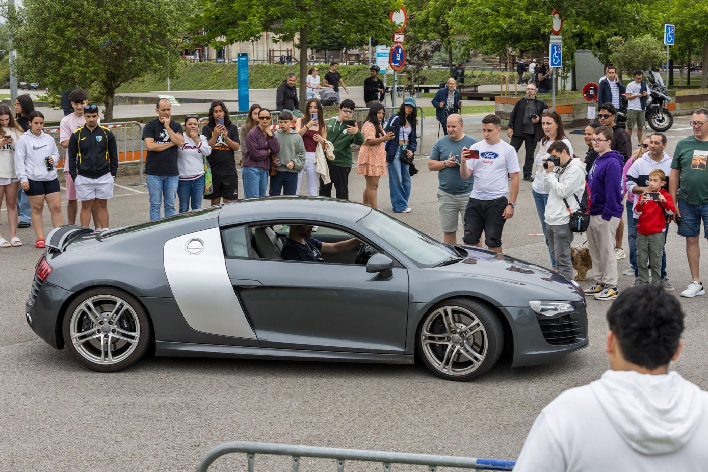 Varias personas fotografían a un Audi R8.