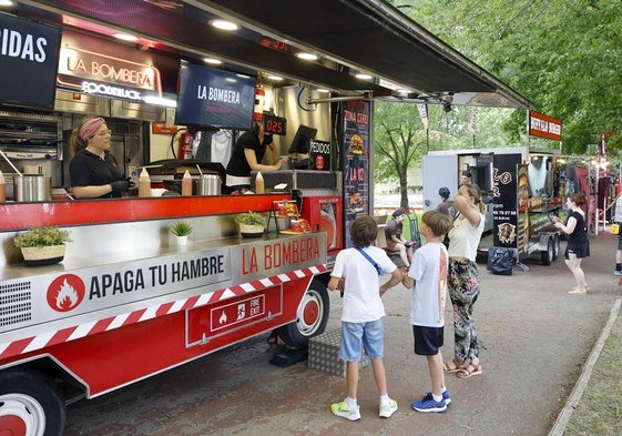 Clientes se interesan ayer por la carta en una de las doce 'foodtrucks' aparcadas en el parque Manuel Barquín de Torrelavega.