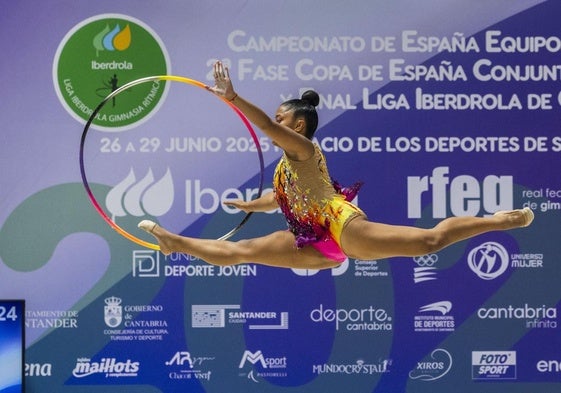 Salto en plena rutina con aro de una de las gimnastas que ayer disputaron en el Palacio de los Deportes el Campeonato de España de conjuntos de gimnasia rítmica .