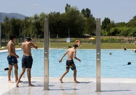 Varios jóvenes disfrutan de un día de calor en la piscina de Tanos.