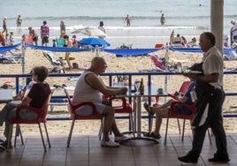 Un camarero atiende una terraza de la Playa de El Sardinero.