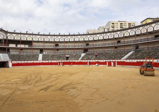 Operarios trabajan en la puesta a punto de Cuatro Caminos y para extender la nueva arena llegada para adecuar el ruedo.