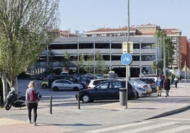 Vecinos caminan junto al aparcamiento de La Carmencita, en Torrelavega.