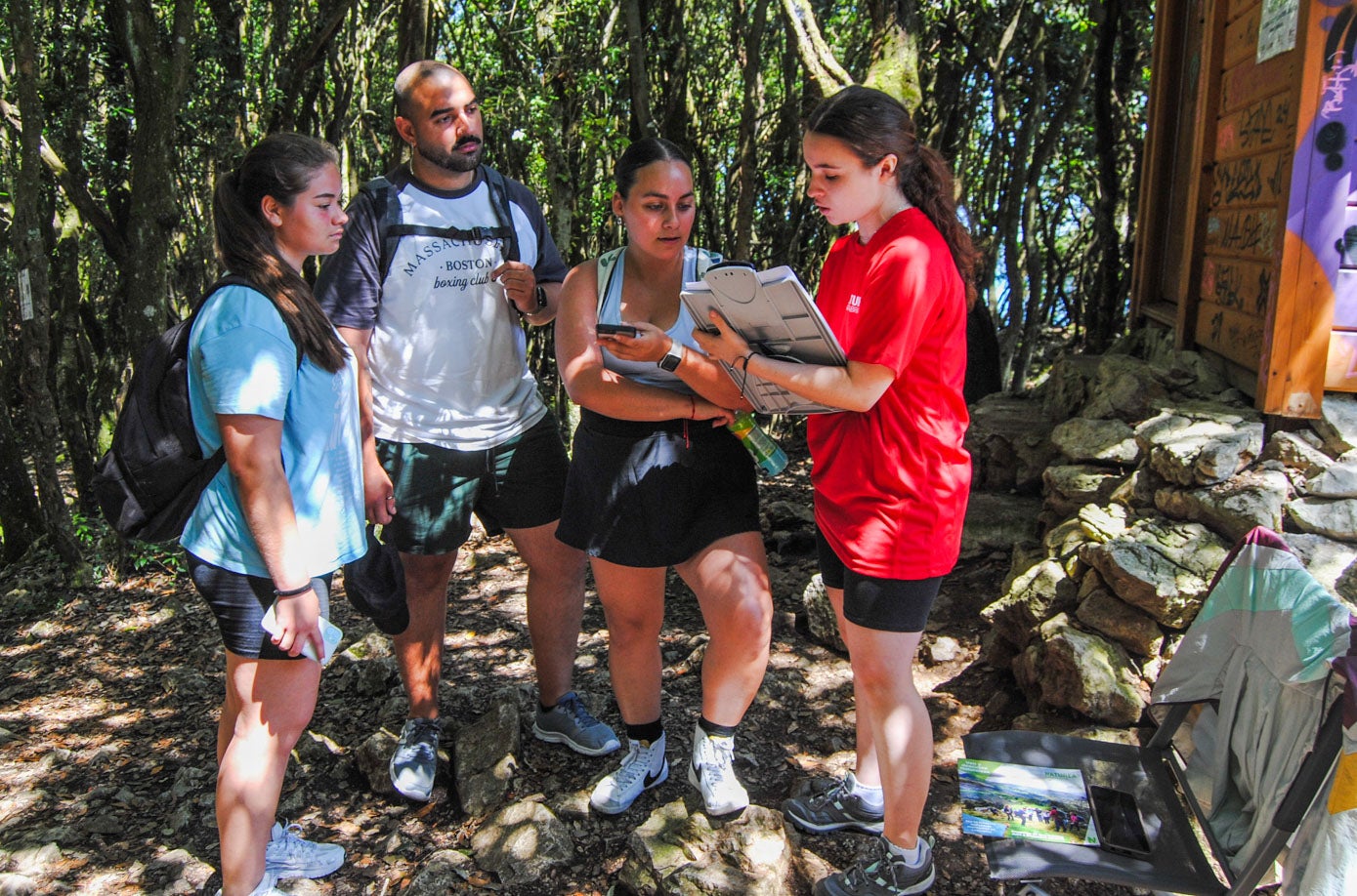 Karen, Christian y Valentina muestran su reserva a la informadora, Ángela Cagigas, para poder bajar al faro.