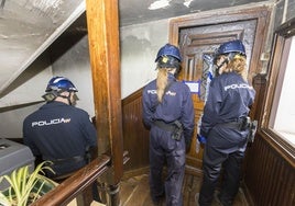 La policía científica entrando en la vivienda incendiada en la calle Juan de la Cosa 33.
