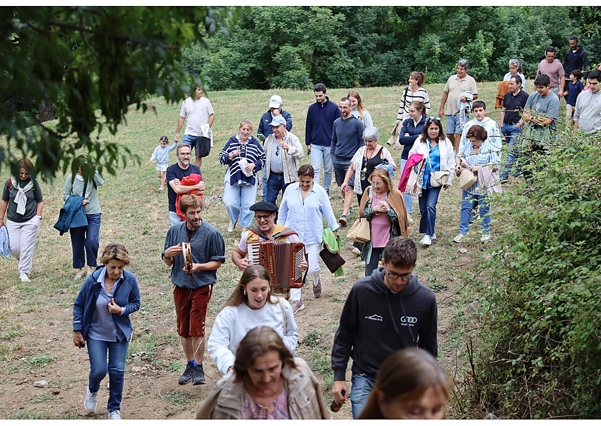 Imagen secundaria 1 - Los músicos durante su actuación, el público camino del concierto bajo la música del acordeón y pandereta, y un vecino realizando el reto ciclista en una bicicleta Specialized