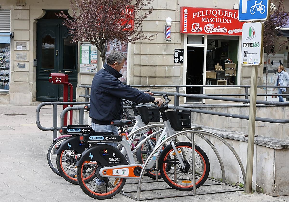 Un usuario agarra una de las bicicletas en Torrelavega.